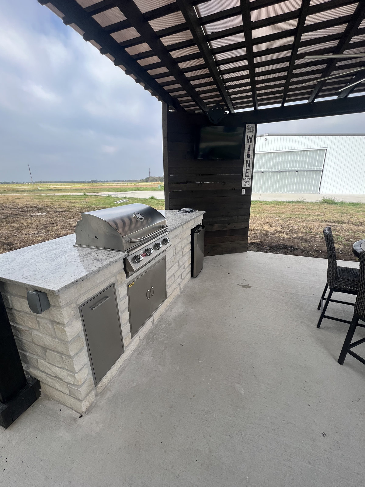 Outdoor kitchen with shade and low wall near Houston